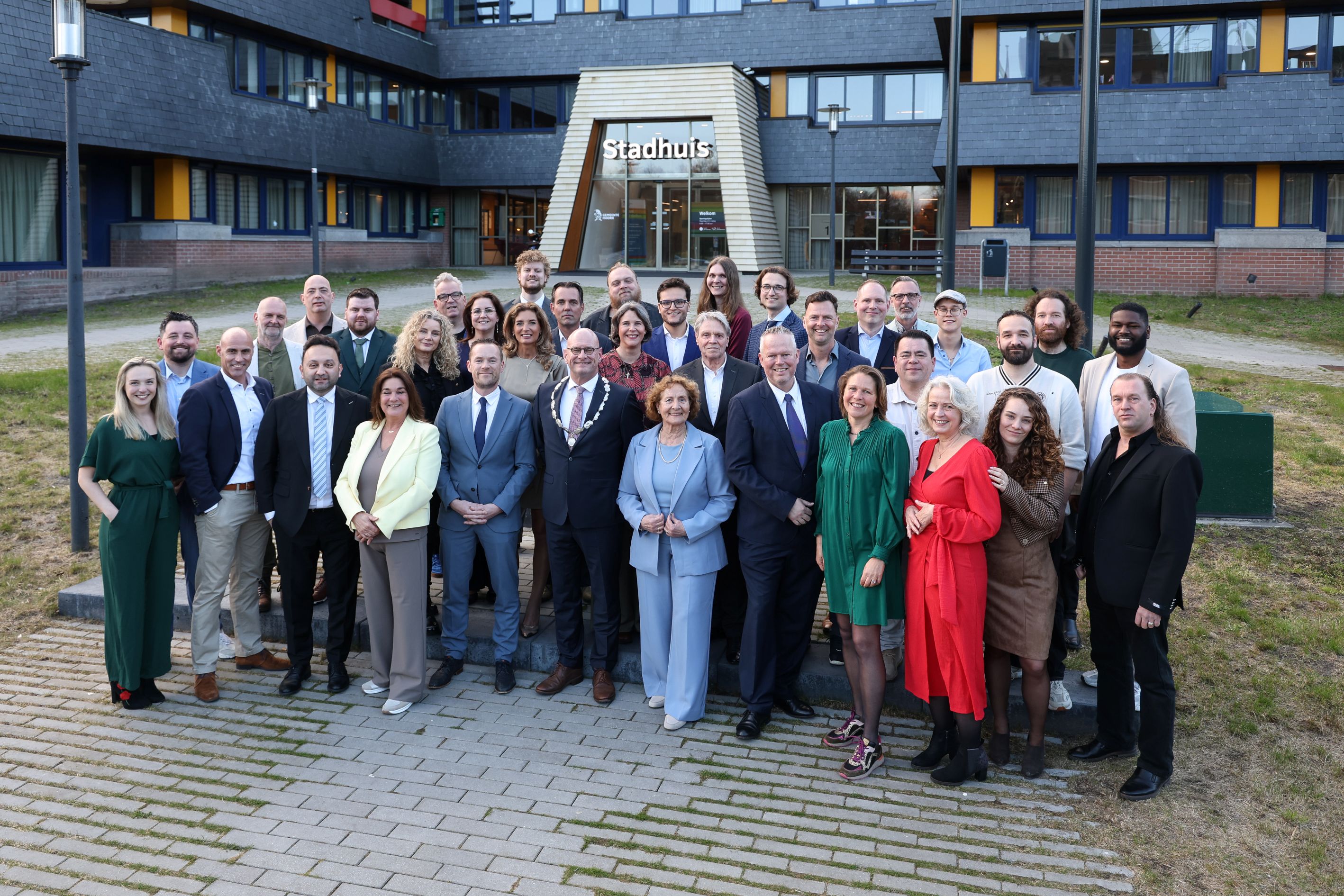 de leden van de gemeenteraad van Hoorn poseren samen met burgemeester Nieuwenburg voor het stadhuis van Hoorn