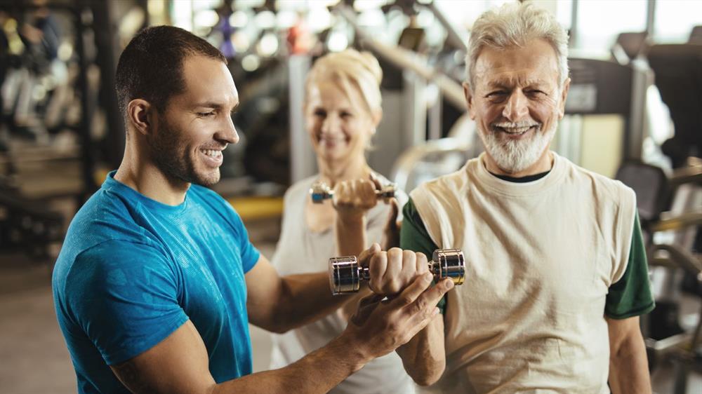 Een sportinstructeur helpt een man met een gewicht