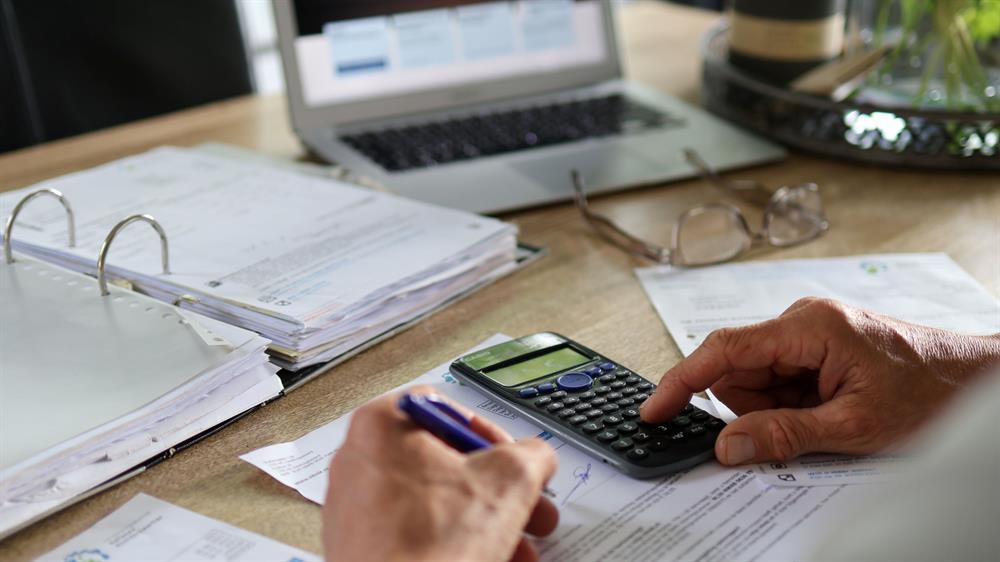 iemand met een rekenmachine en papieren iemand met een rekenmachine en papieren