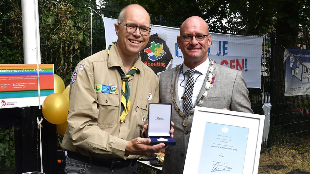 De voorzitter van Scoutinggroep MLK ontvangt de feestelijkheden van de burgemeester De voorzitter van Scoutinggroep MLK ontvangt de feestelijkheden van de burgemeester