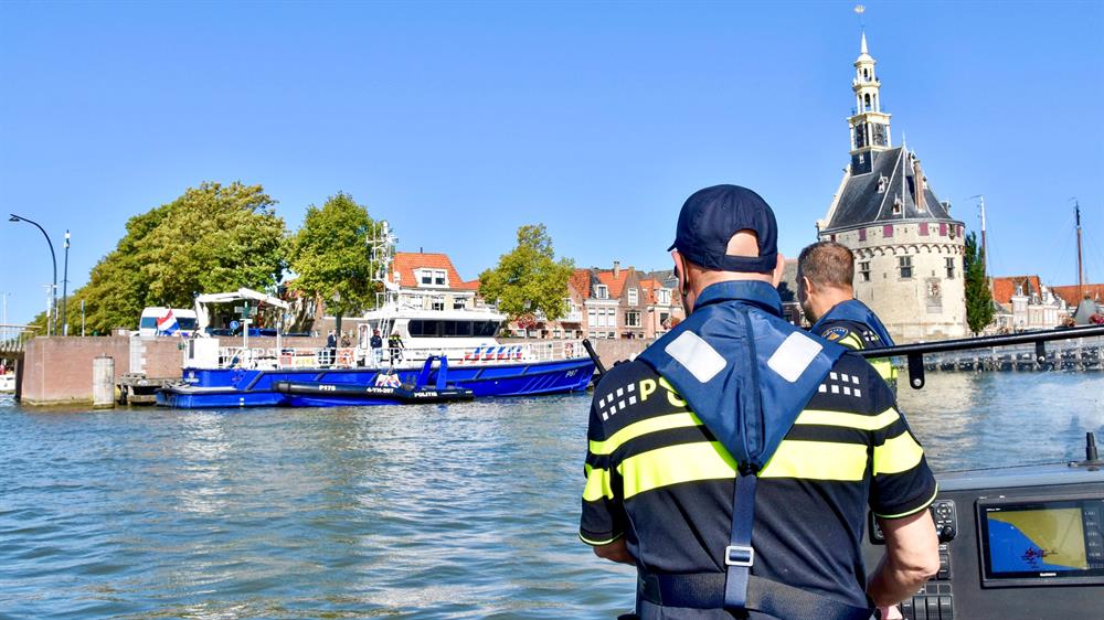Een politieagent op een boot in de haven van Hoorn