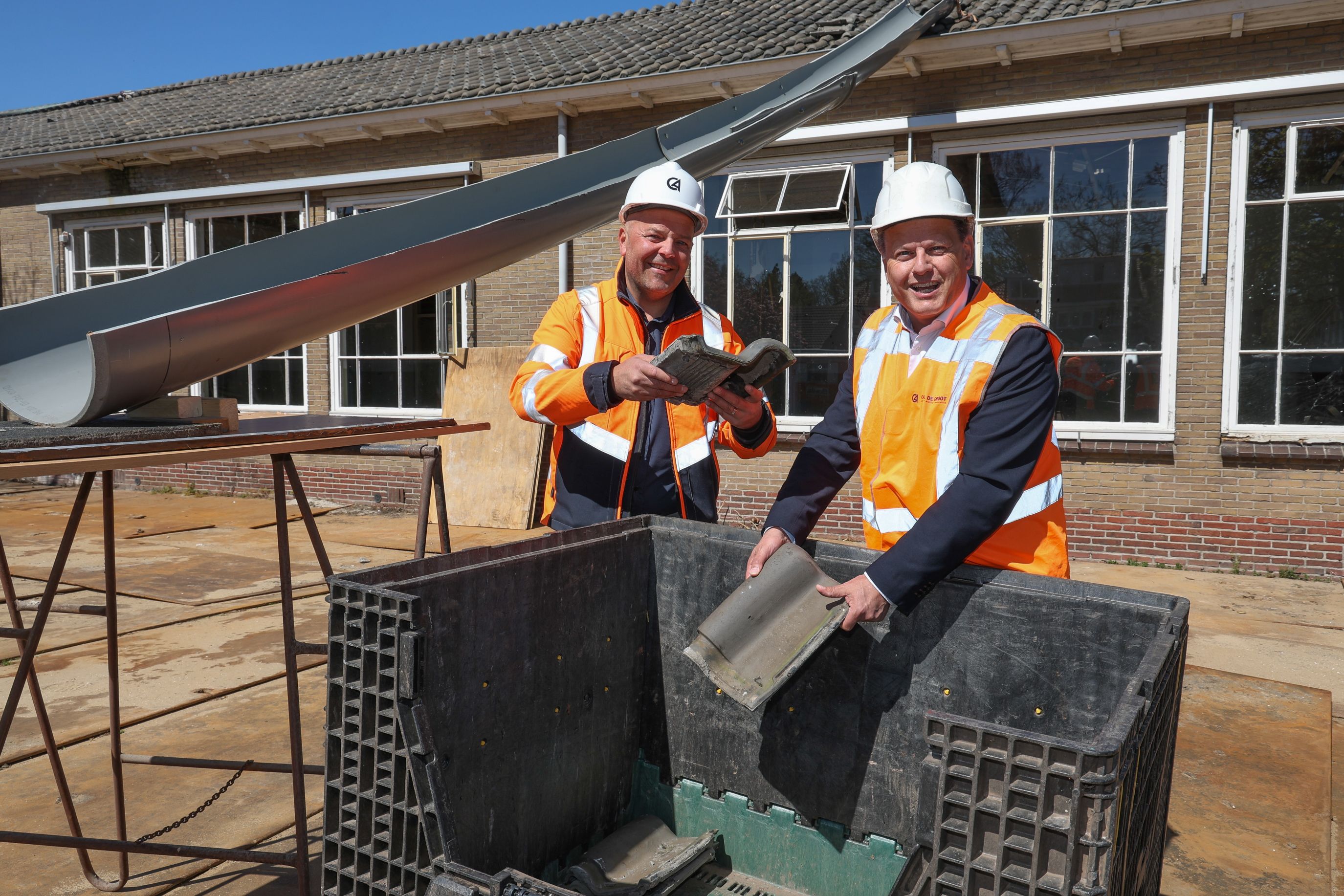 Kees de Groot en René Assendelft met de dakpannen van de voormalige IKEC Abbingstraat
