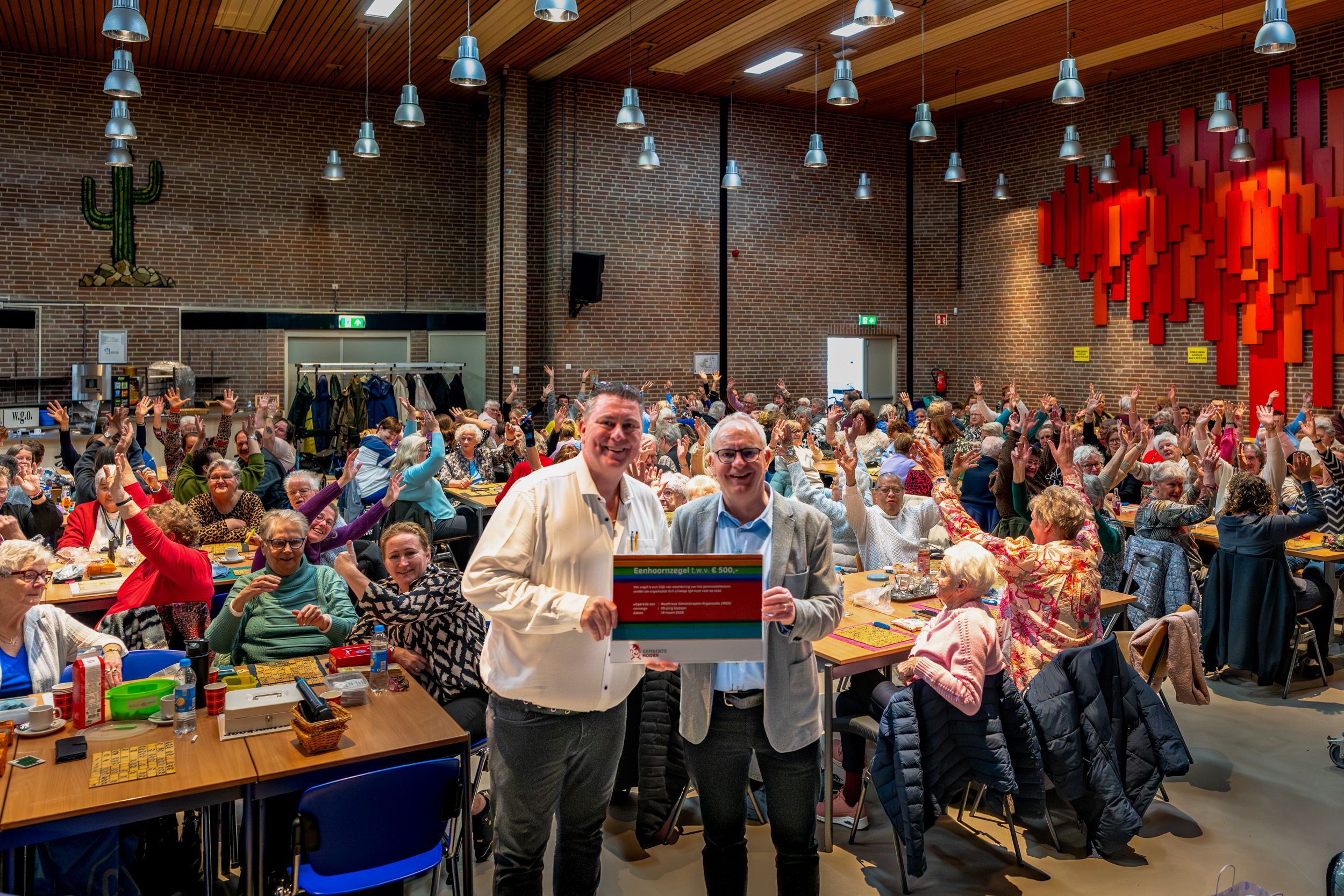 Wethouder Bennis overhandigt het Eenhoornzegel aan voorzitter Patrick Cousijn
