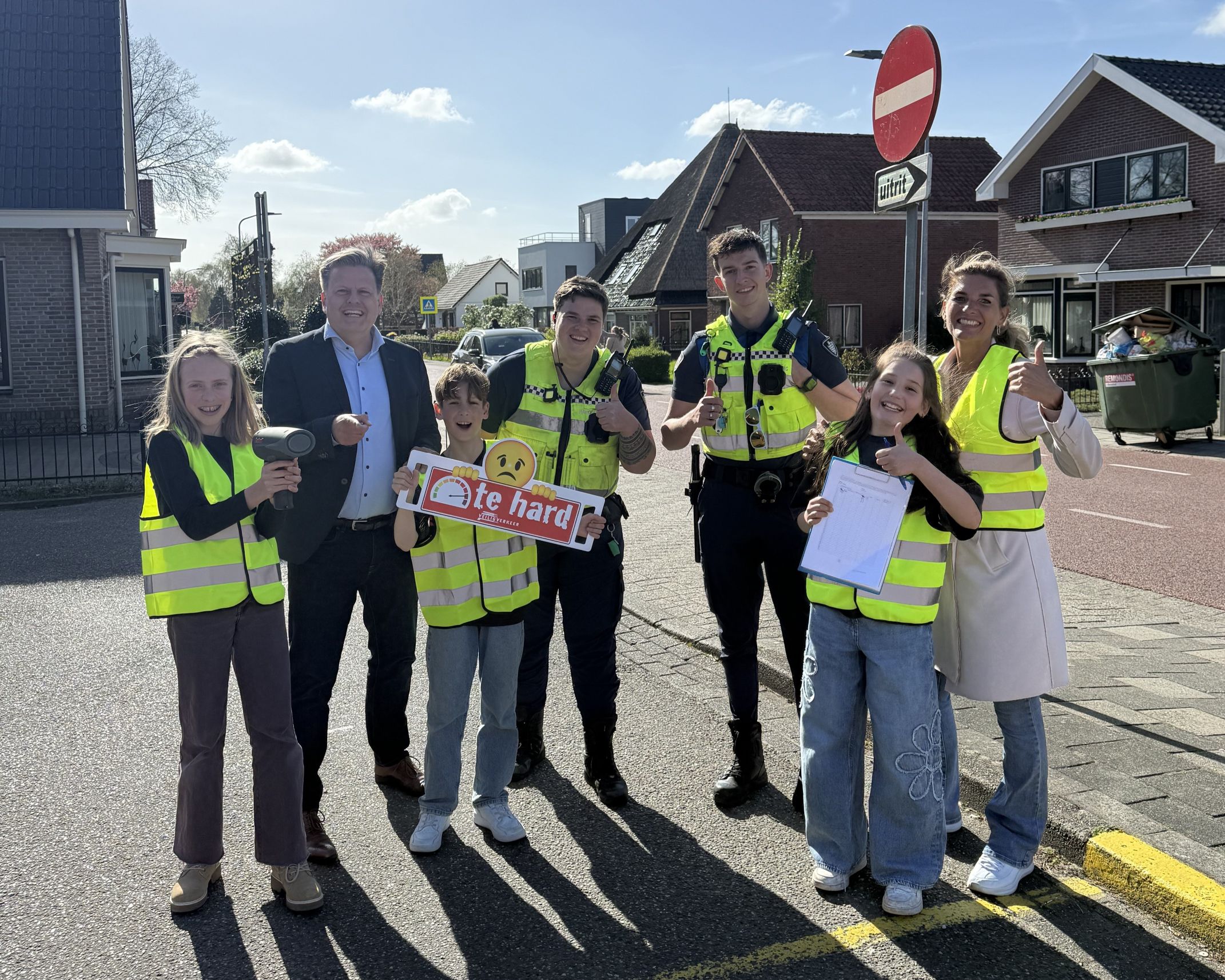 Leden van de kindergemeenteraad, handhavers, wethouder Assendelft en raadslid Katers aan de Dorpsstraat