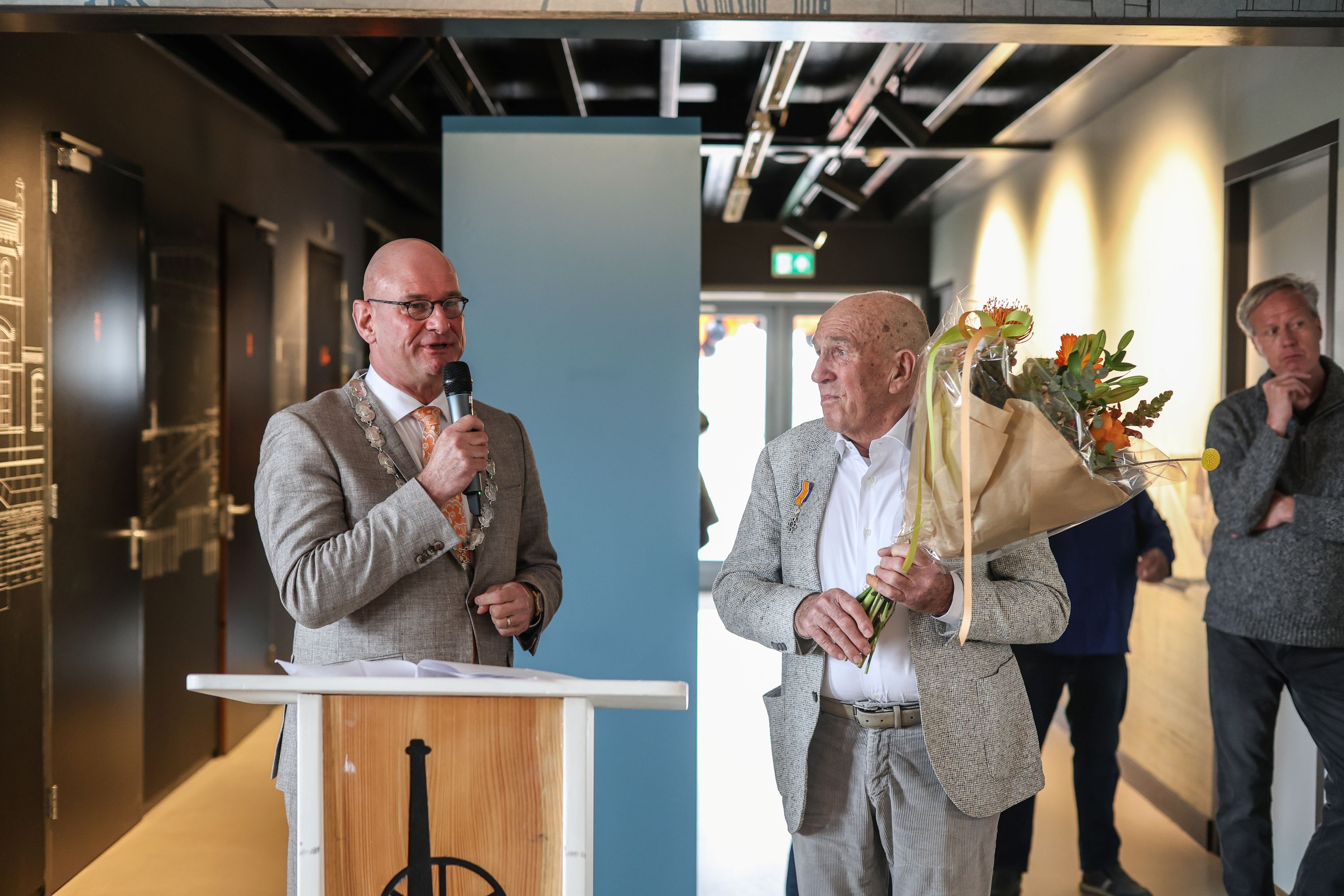 Burgemeester Nieuwenburg spreekt de heer Van Eijk toe